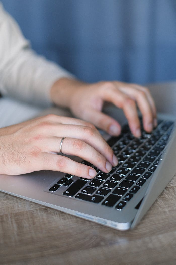 Hands typing on a laptop keyboard, emphasizing technology and productivity.